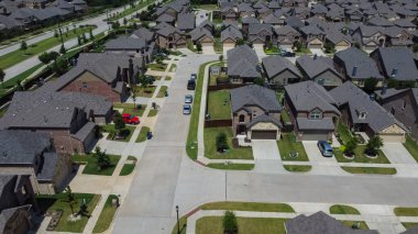 McKinney, TX USA - 5 Ağustos 2022: McKinney 'de bitkileri ve garaj yolu olan toplu konutların havadan görünüşü