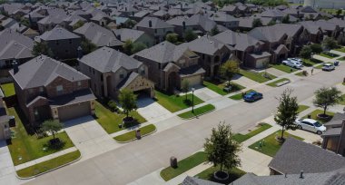 McKinney, TX USA - 5 Ağustos 2022: McKinney 'de bitkileri ve garaj yolu olan toplu konutların havadan görünüşü