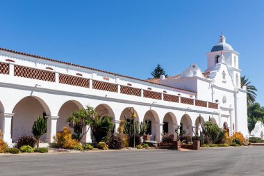OCEANSIDE, CALIFORNIA, ABD - 3 Eylül 2021: 1798 'de kurulan San Luis Rey Misyonu' nun mavi kubbesi ve koridor kemerleriyle restore edilen kilise cephesi.