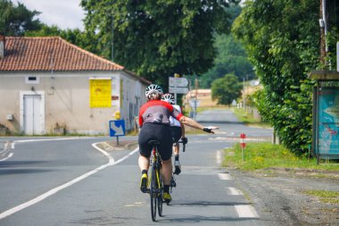 Dordogne, France July 02 2023: Cyclist Indicating a Direction on the Road clipart