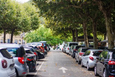 Sarlat, Fransa 07 Ağustos 2023: Yeşil Oasis: Ağaçların Altında Park Edilmiş Arabalar Kentsel Ekolojiyi Vurguluyor.