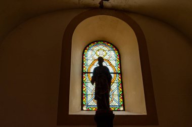 Castelaud la Chapelle, Fransa 17 Eylül 2023: Devamlılığın Silüeti: Lekeli Cam Pencerenin Önündeki Heykel