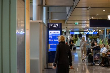 Helsinki-Vantaa Havaalanı, Finlandiya, 24 Ekim 2023: New York uçağı için 47 numaralı kapıda bekleyen yolcular