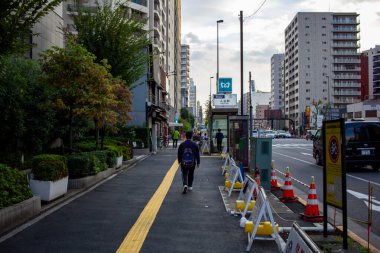 Tokyo, Japonya, 25 Ekim 2023: İnşaat Bariyerleriyle Şehir Sokağında Yürüyen Yaya