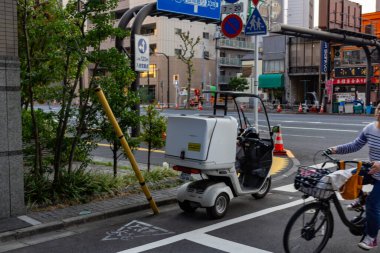 Tokyo, Japonya, 25 Ekim 2023: Yoğun Tokyo Caddesinde Bisikletçiler ve Elektrikli Araç
