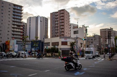 Tokyo, Japonya, 25 Ekim 2023: Tokyo 'da Günbatımında Şehir Kavşağında motosikletçi