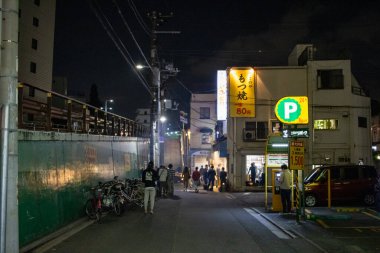 Tokyo, Japonya, 25 Ekim 2023: Yayalar ve Park Tabelasıyla Gece Sokağı Manzarası
