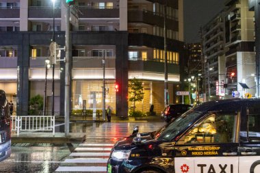 Tokyo, Japonya, 25 Ekim 2023: Tokyo 'da Gece Yağmurlu Kavşakta Bekleyen Taksi