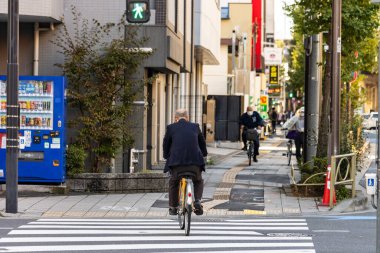 Tokyo, Japonya, 26 Ekim 2023: İş adamı Pedestrian Crossing ile Şehir Caddesinde Bisiklet sürüyor