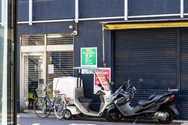 Tokyo, Japonya, 26 Ekim 2023: Park halindeki bisiklet ve motosiklet