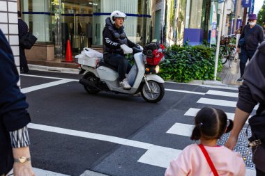 Tokyo, Japonya, 26 Ekim 2023: Şehir Kavşağında Scooter 'da Teslimat Kişi