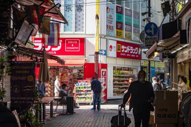 Tokyo, Japonya, 26 Ekim 2023: Çeşitli perakende mağazaları ve müşterileri olan alışveriş caddesi