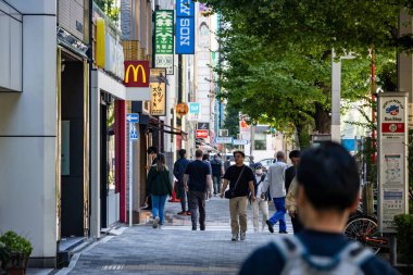 Tokyo, Japonya, 26 Ekim 2023: Tokyo 'da yayalar ve önde gelen fast-food tabelalarıyla dolu bir alışveriş caddesi.