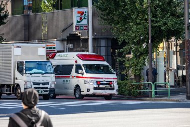 Tokyo, Japonya, 26 Ekim 2023: Bir bakkal yakınlarındaki trafikte ambulans