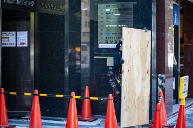 Tokyo, Japonya, 26 Ekim 2023: Uyarı konileri ve ahşap panellerle inşa alanı