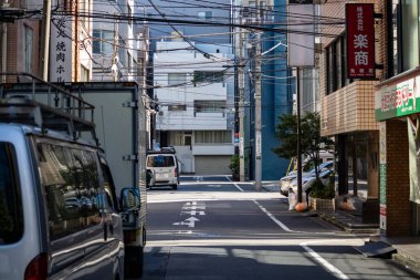 Tokyo, Japonya, 26 Ekim 2023: Park halindeki arabalar ve elektrik hatlarıyla sessiz bir ara sokak