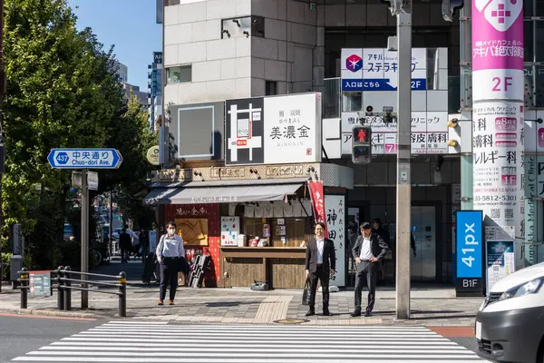 Tokyo, Japonya, 26 Ekim 2023: Bir şehir kavşağında karşıdan karşıya geçen yayalar