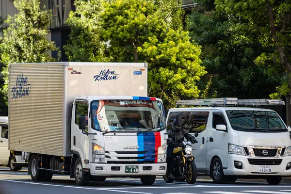 Tokyo, Japonya, 26 Ekim 2023: Tokyo 'nun iş bölgesinde bir caddeye park edilmiş teslimat kamyonları