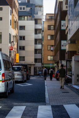 Tokyo, Japonya, 26 Ekim 2023: Tokyo 'da yayalar ve park edilmiş araçlarla sokak manzarası