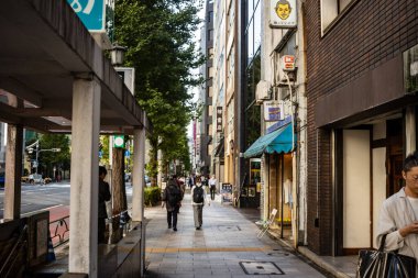 Tokyo, Japonya, 26 Ekim 2023: Sabahın erken saatlerinde Dükkanlar ve yayalarla Sessiz Sokak