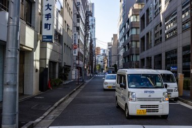 Tokyo, Japonya, 26 Ekim 2023: Park halindeki araçlar ve ofis binalarıyla sessiz bir ara sokak