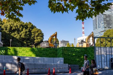 Tokyo, Japonya, 26 Ekim 2023: Yeşilliğin Ardında Kazıcı Arkasında İnşaat Alanı