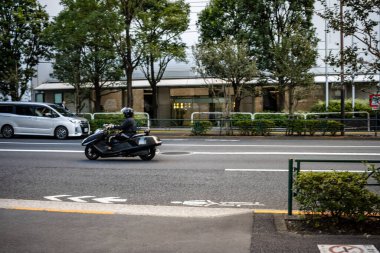 Tokyo, Japonya, 26 Ekim 2023: Şehir merkezinde trafik ışıklarında bekleyen motosikletli