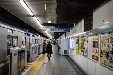 Tokyo, Japonya, 26 Ekim 2023: Bir Tokyo metro istasyonunda anime posterli banliyö sakinleri