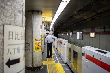 Tokyo, Japonya, 26 Ekim 2023: Yön tabelaları ve reklamları olan metro istasyonu sütunu