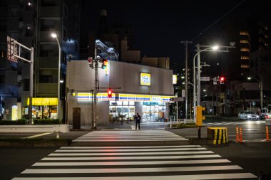 Tokyo, Japonya, 26 Ekim 2023: Şehir caddesindeki parlak ışıklı bir marketin gece manzarası