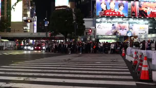 2023年11月22日 夜の東京の忙しい交差点を横断するスクーターライダー — ストック動画