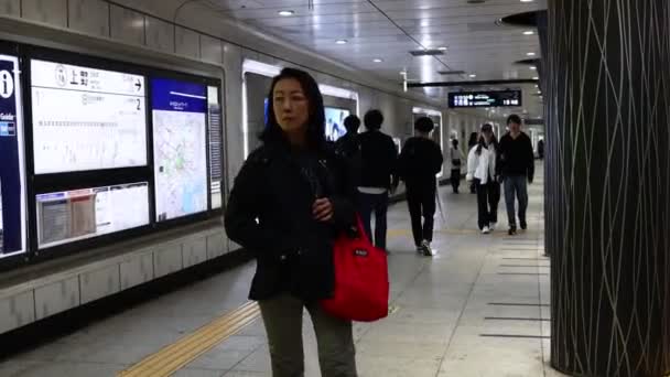11月2023日 情報ディスプレイで駅で待機する通勤者 — ストック動画
