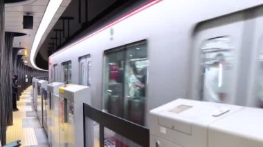 Tokyo, Japonya, 22 Kasım 2023: Boş trenler ve bekleyen yolcularla metro peronu