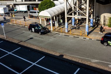 Tokyo, Japonya, 27 Kasım 2023: Park halindeki kamyonlar ve yaya geçidi ile şehir caddesinin hava görüntüsü