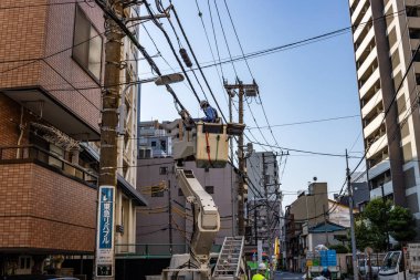 Tokyo, Japonya, 27 Ekim 2023: Kiraz Toplayıcı 'dan Elektrik Hatlarını Tamir Eden Elektrik İşçileri