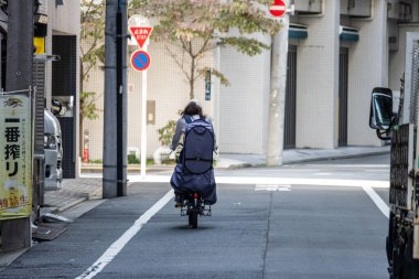 Tokyo, Japonya, 27 Ekim 2023: Şehir Yolunda Teslimat Scooter Sürücüsü
