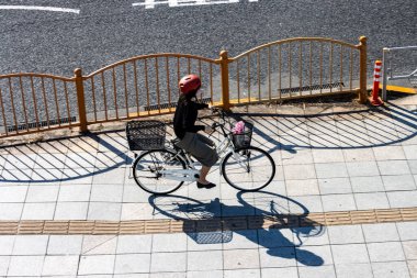 Tokyo, Japonya, 27 Ekim 2023: Bisikletçi inşaat alanının etrafından geçiyor