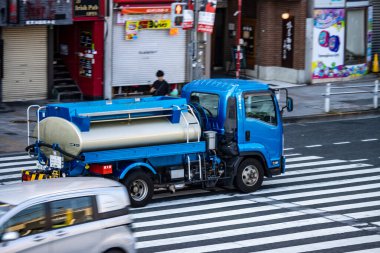 Tokyo, Japonya, 27 Ekim 2023: Şehir trafiğinde karşıdan karşıya geçen su tankeri