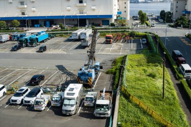 Tokyo, Japonya, 27 Ekim 2023: Endüstri bölgesi yakınlarında çeşitli araçları olan park yeri