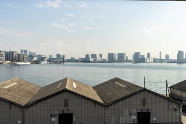 Tokyo, Japonya, 27 Ekim 2023: Arkaplanda City Skyline olan liman depoları