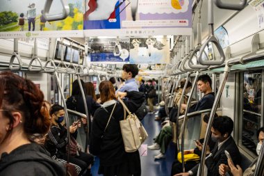 Tokyo, Japonya, 27 Ekim 2023: Yoğun bir Tokyo metro vagonundaki yolcular