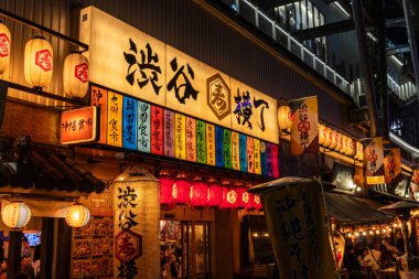 Tokyo, Japonya, 27 Ekim 2023: Geleneksel bir restoranın önünde renkli pankartlar ve fenerler