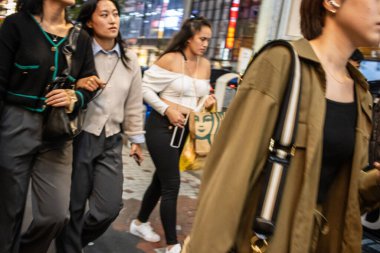 Tokyo, Japonya, 27 Ekim 2023: Bir grup arkadaş gece Tokyo 'da yürüyor