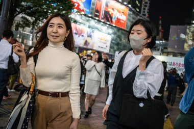 Tokyo, Japonya, 27 Ekim 2023: Shibuya Geçidi 'nde yürüyen gülümseyen kadın