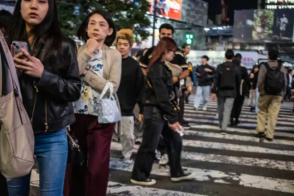 Tokyo, Japonya, 27 Ekim 2023: Shibuya Geçidi 'nde akıllı telefon kullanan genç bireyler