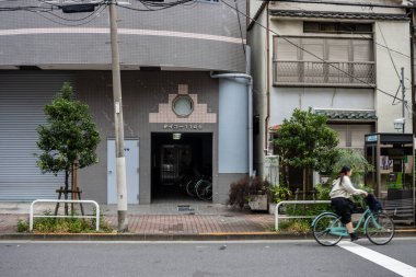Tokyo, Japonya, 28 Ekim 2023: Tokyo 'daki yerleşim alanlarından geçen bisikletçi
