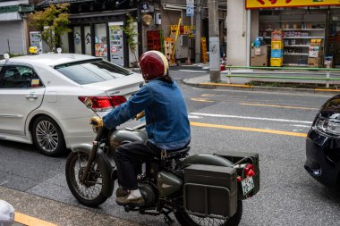 Tokyo, Japonya, 28 Ekim 2023: Tokyo 'da bir trafik ışıklarında bekleyen motosikletli