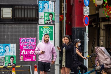 Tokyo, Japonya, 28 Ekim 2023: Tokyo 'da insanlar sokak reklamlarıyla yürüyor