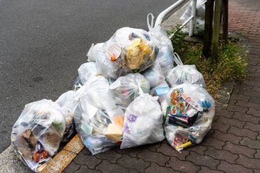 Tokyo, Japonya, 28 Ekim 2023: Sokağa saydam çöp torbaları yığını