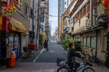 Tokyo, Japonya, 28 Ekim 2023: Tokyo 'da ilginç bir caddede asılı süslemeleri olan bisikletçi